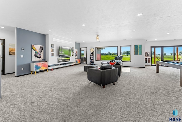 rec room featuring light colored carpet and a textured ceiling