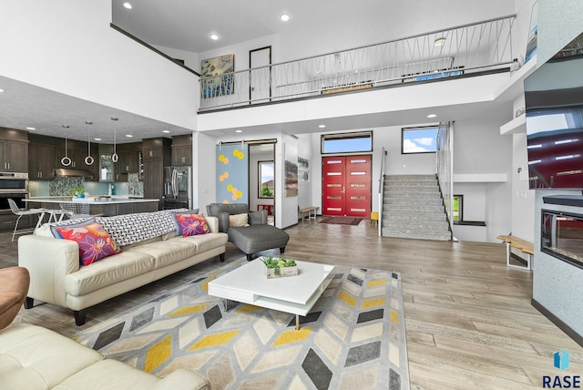 living room featuring a high ceiling and light hardwood / wood-style flooring