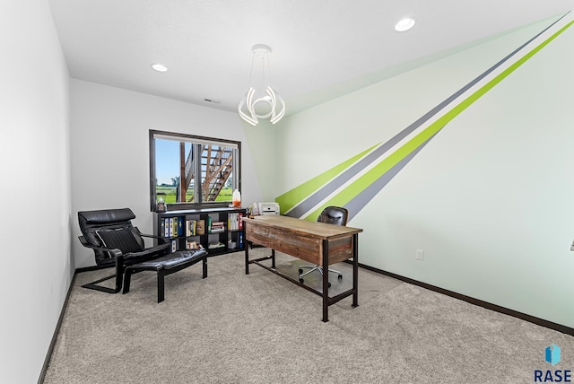 carpeted home office featuring an inviting chandelier