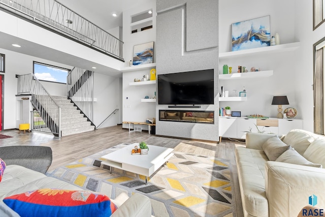 living room featuring hardwood / wood-style flooring and a towering ceiling