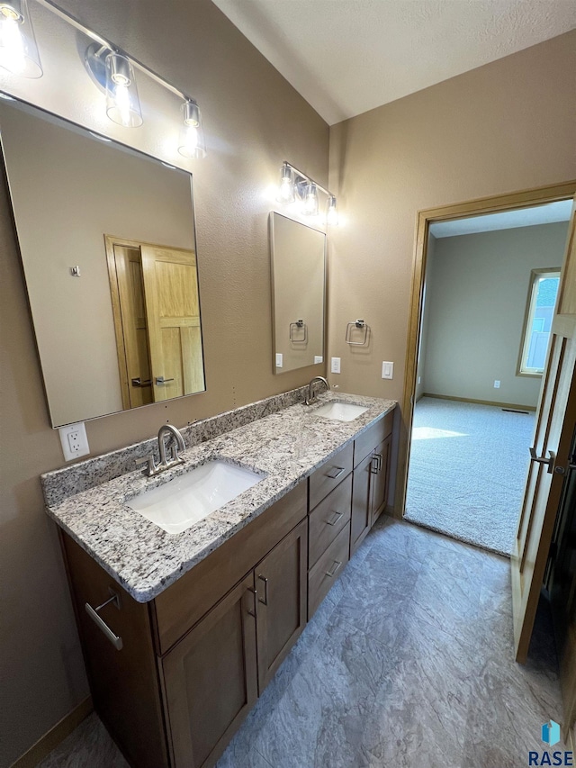 bathroom featuring a textured ceiling and vanity