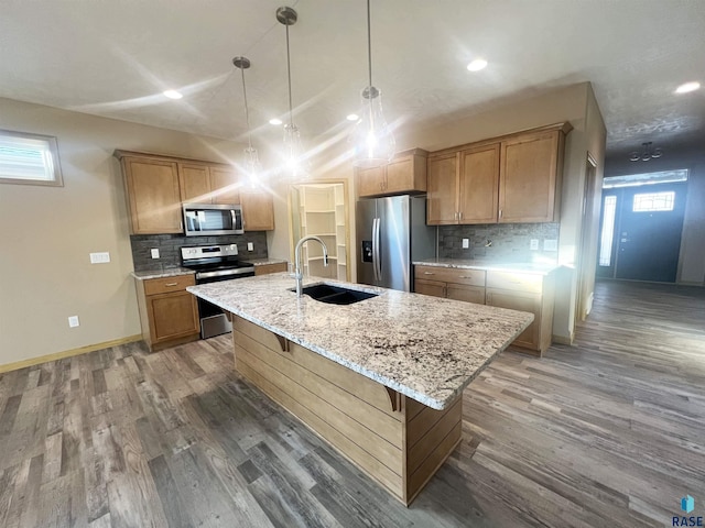 kitchen with sink, a center island with sink, hardwood / wood-style floors, and stainless steel appliances