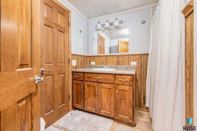 bathroom featuring vanity, crown molding, tile patterned floors, and wood walls