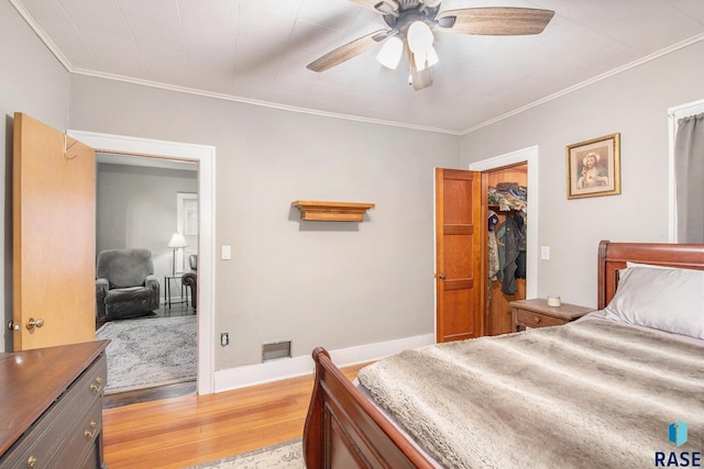 bedroom featuring ornamental molding, light hardwood / wood-style flooring, ceiling fan, and a closet