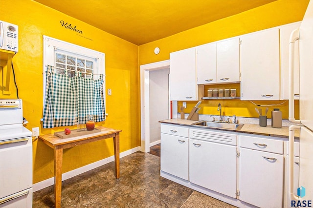 kitchen with range with electric stovetop, sink, white cabinets, and white refrigerator