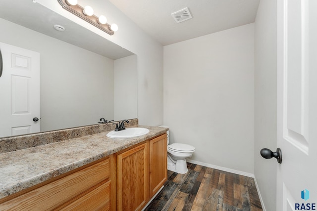 bathroom with vanity, hardwood / wood-style flooring, and toilet