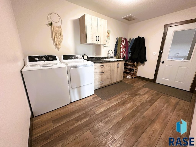 laundry area featuring cabinets, separate washer and dryer, sink, and dark hardwood / wood-style floors