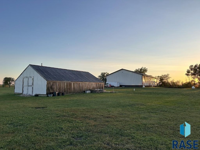 yard at dusk featuring an outbuilding