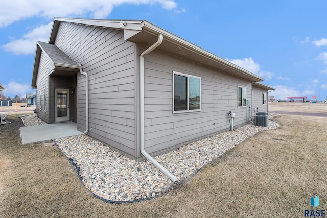 view of home's exterior featuring a patio, a yard, and central AC unit