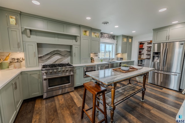 kitchen featuring stainless steel appliances, tasteful backsplash, dark wood-type flooring, and green cabinetry