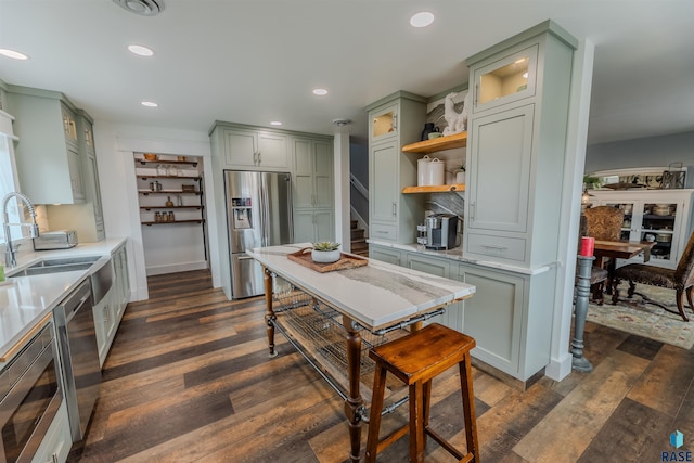 kitchen with sink, dark hardwood / wood-style floors, green cabinetry, and appliances with stainless steel finishes