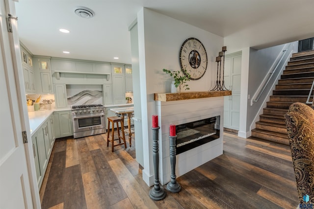 kitchen with dark hardwood / wood-style flooring, tasteful backsplash, and high end stove