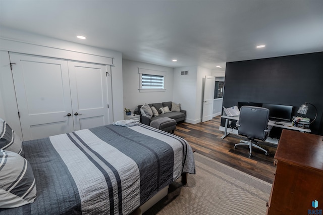 bedroom with dark hardwood / wood-style floors and a closet