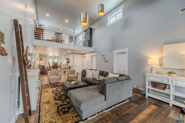 living room with dark wood-type flooring and a high ceiling