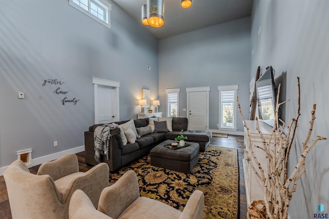 living room with hardwood / wood-style flooring and a towering ceiling