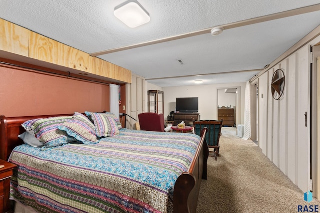 bedroom featuring a textured ceiling and carpet flooring