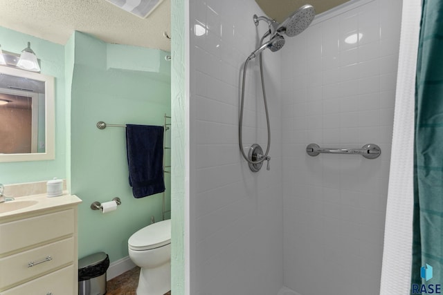 bathroom with vanity, toilet, a shower with shower curtain, and a textured ceiling