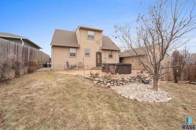 back of house with a lawn, a hot tub, and a patio