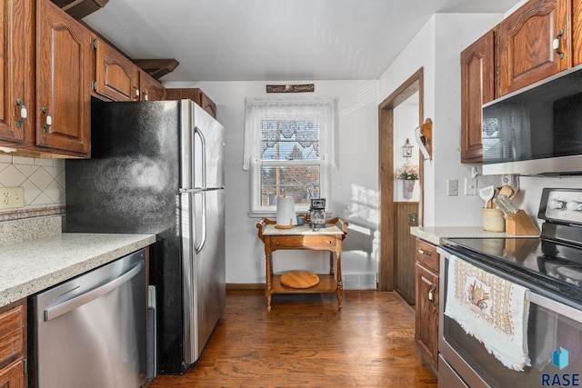 kitchen with stainless steel appliances, tasteful backsplash, and dark wood-type flooring