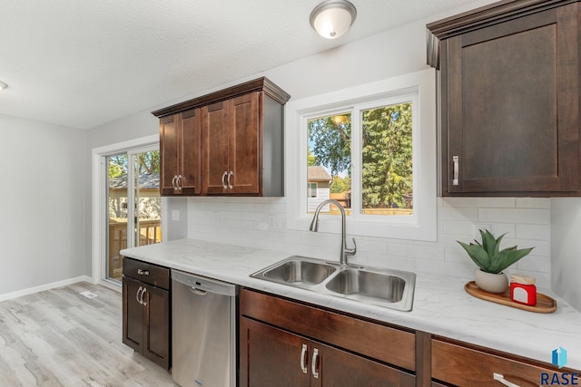 kitchen with dark brown cabinets, sink, stainless steel dishwasher, and light hardwood / wood-style flooring