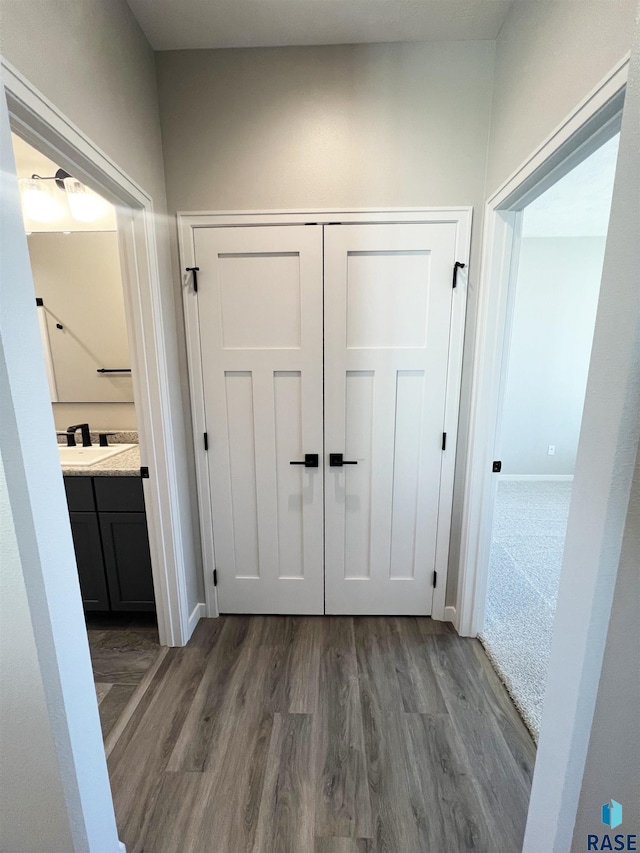 corridor with wood finished floors and baseboards