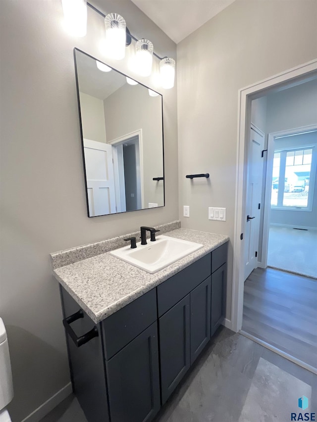 half bath featuring marble finish floor, baseboards, and vanity