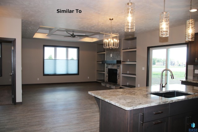 kitchen with open floor plan, decorative light fixtures, and a sink