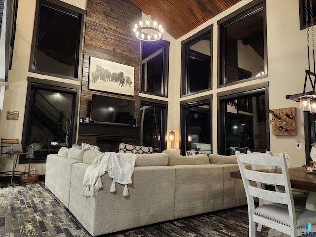 living room featuring dark hardwood / wood-style flooring, high vaulted ceiling, wooden ceiling, and a chandelier