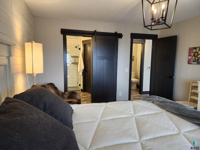 bedroom with a barn door and connected bathroom