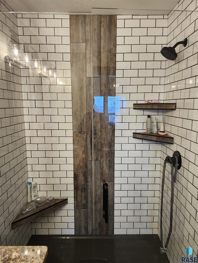 bathroom with a textured ceiling and a shower with shower door