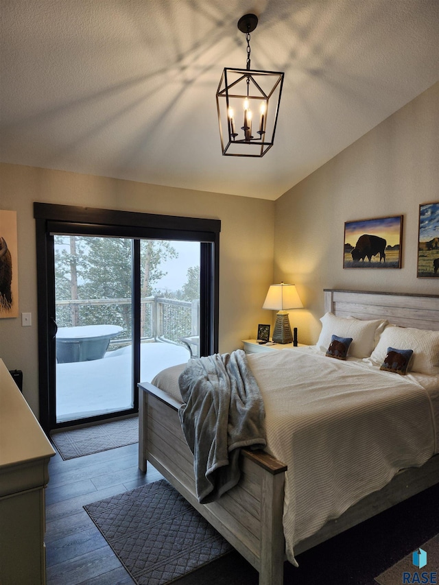 bedroom with multiple windows, access to exterior, dark hardwood / wood-style flooring, and a chandelier