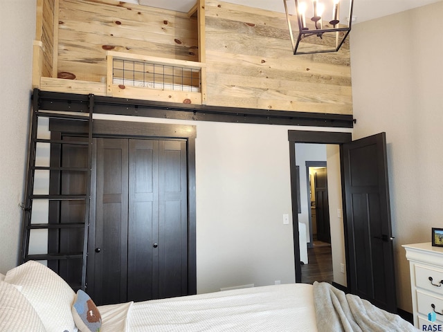 bedroom with a closet and wood walls