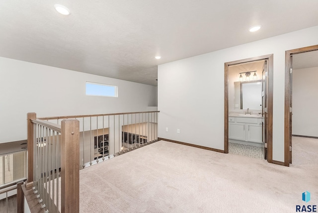 bonus room with sink and light carpet