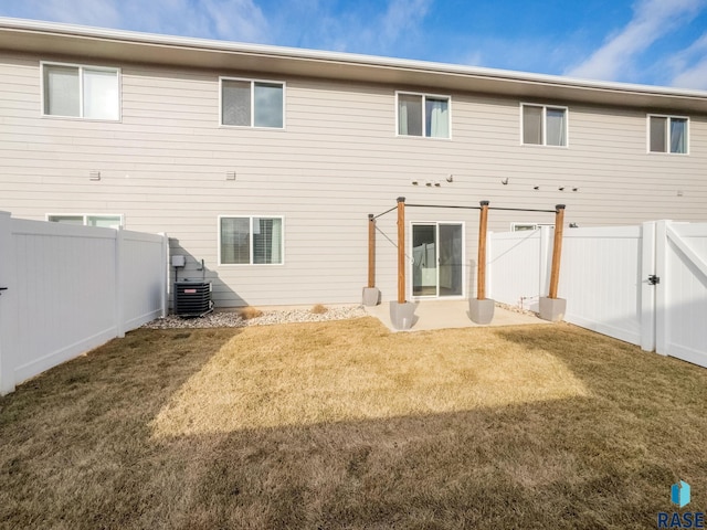 rear view of house featuring a yard and central AC