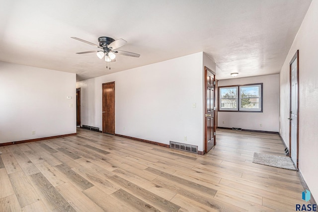 spare room with ceiling fan and light wood-type flooring