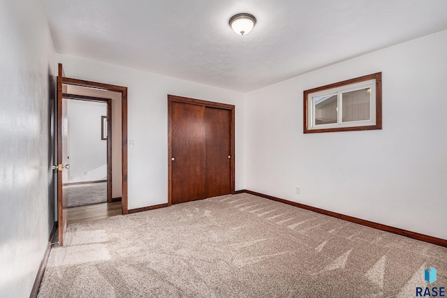 unfurnished bedroom featuring light colored carpet and a closet