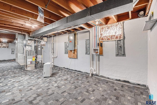 basement featuring gas water heater, electric panel, and carpet