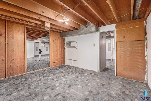 basement with wood walls and dark colored carpet