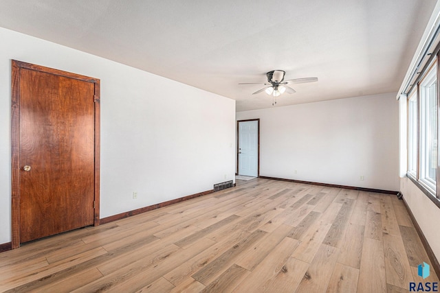 empty room featuring ceiling fan and light hardwood / wood-style floors