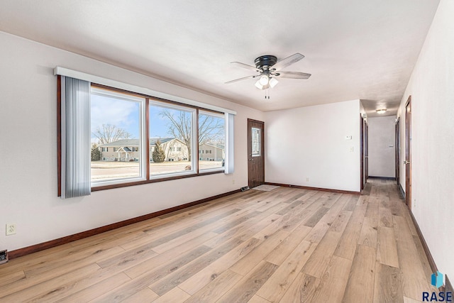 empty room with ceiling fan and light hardwood / wood-style floors