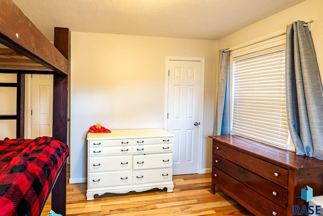 bedroom featuring light hardwood / wood-style floors and a textured ceiling