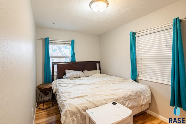 bedroom with hardwood / wood-style floors and a textured ceiling