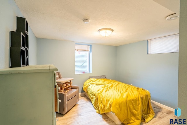 bedroom featuring light hardwood / wood-style flooring and a textured ceiling