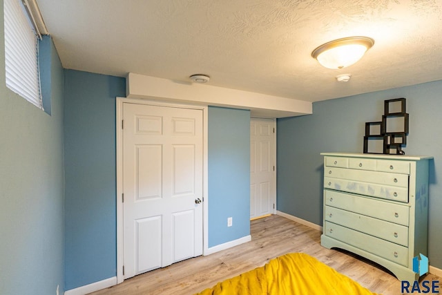 bedroom featuring a textured ceiling and light wood-type flooring