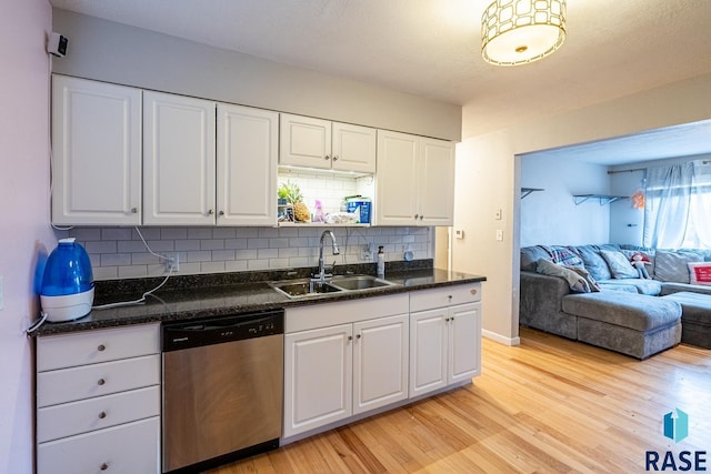 kitchen featuring white cabinetry, dishwasher, sink, and tasteful backsplash