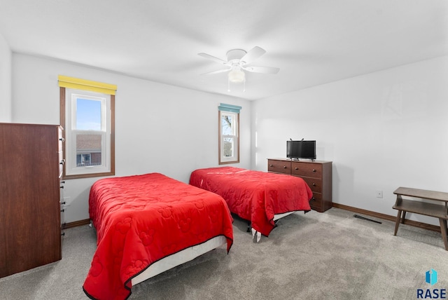 bedroom featuring multiple windows, light carpet, and ceiling fan