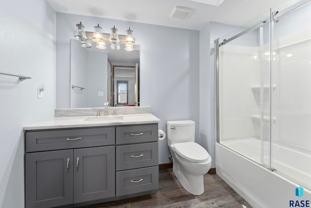 full bathroom featuring enclosed tub / shower combo, wood-type flooring, vanity, and toilet