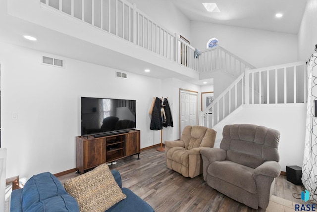 living room with a towering ceiling and hardwood / wood-style floors