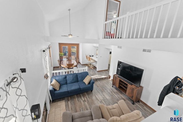 living room featuring hardwood / wood-style flooring, ceiling fan, high vaulted ceiling, and french doors