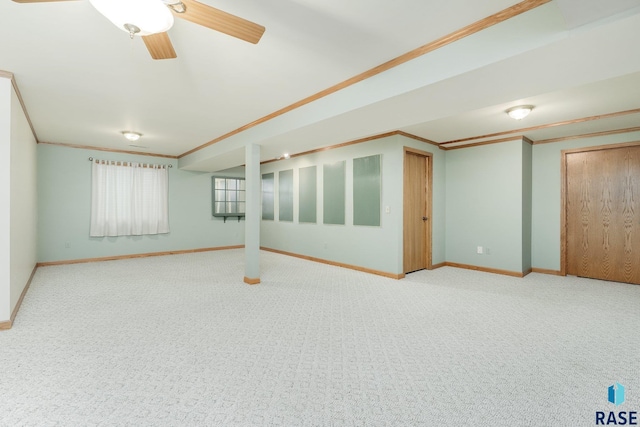 basement featuring ornamental molding, ceiling fan, and carpet